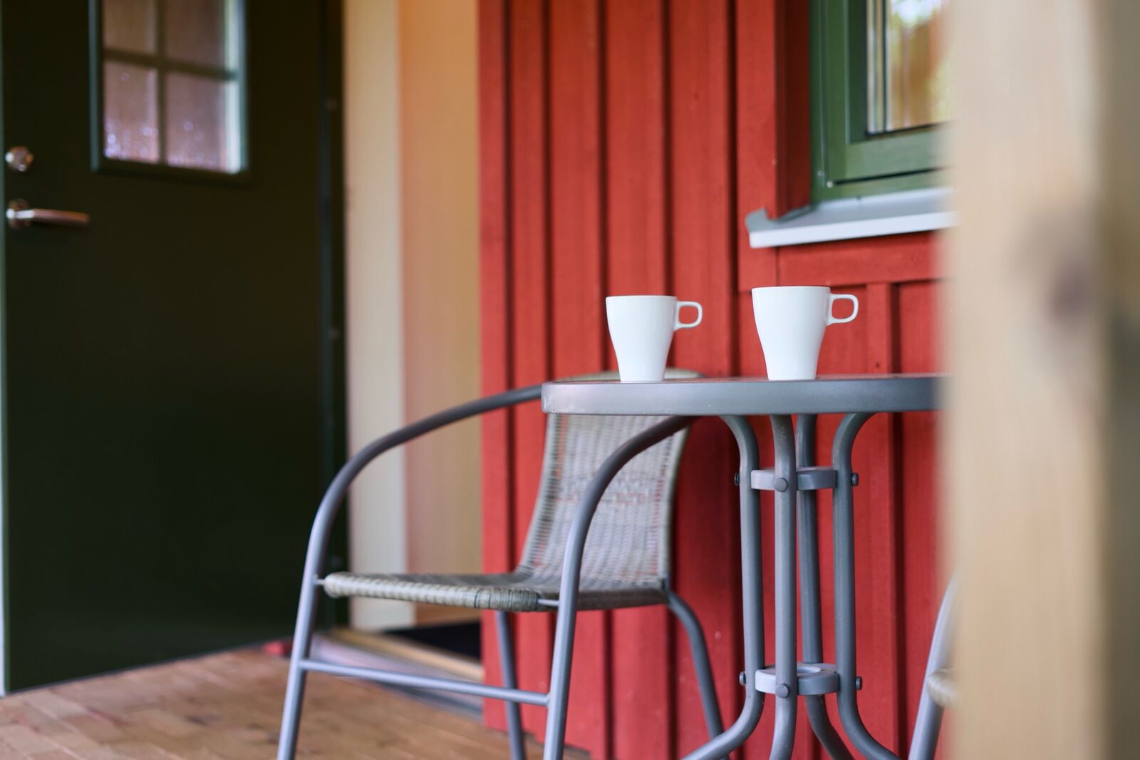 Två kaffekoppar på verandabordet utanför rummet