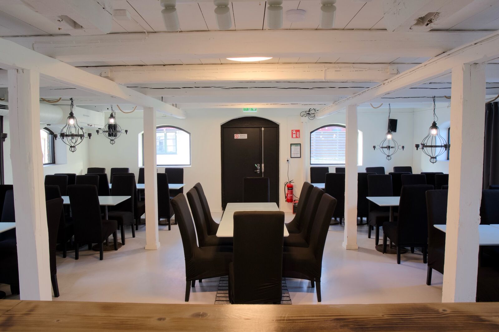 Festsalen sedd från scenen med bord och svarta stolar